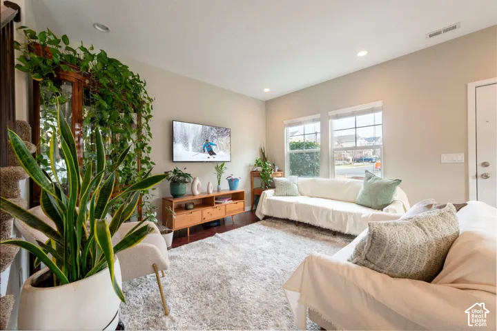 Recessed ceiling lighting, wood-finish flooring, and multiple windows with blinds
