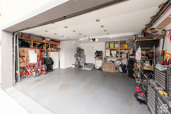 Two-car garage with painted concrete flooring and overhead storage