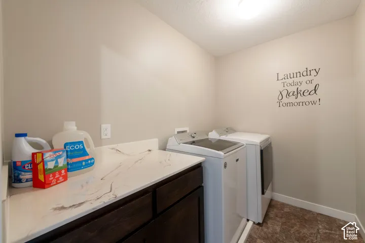 Laundry area featuring a built-in counter, dark wood-finish cabinetry, and neutral wall paint