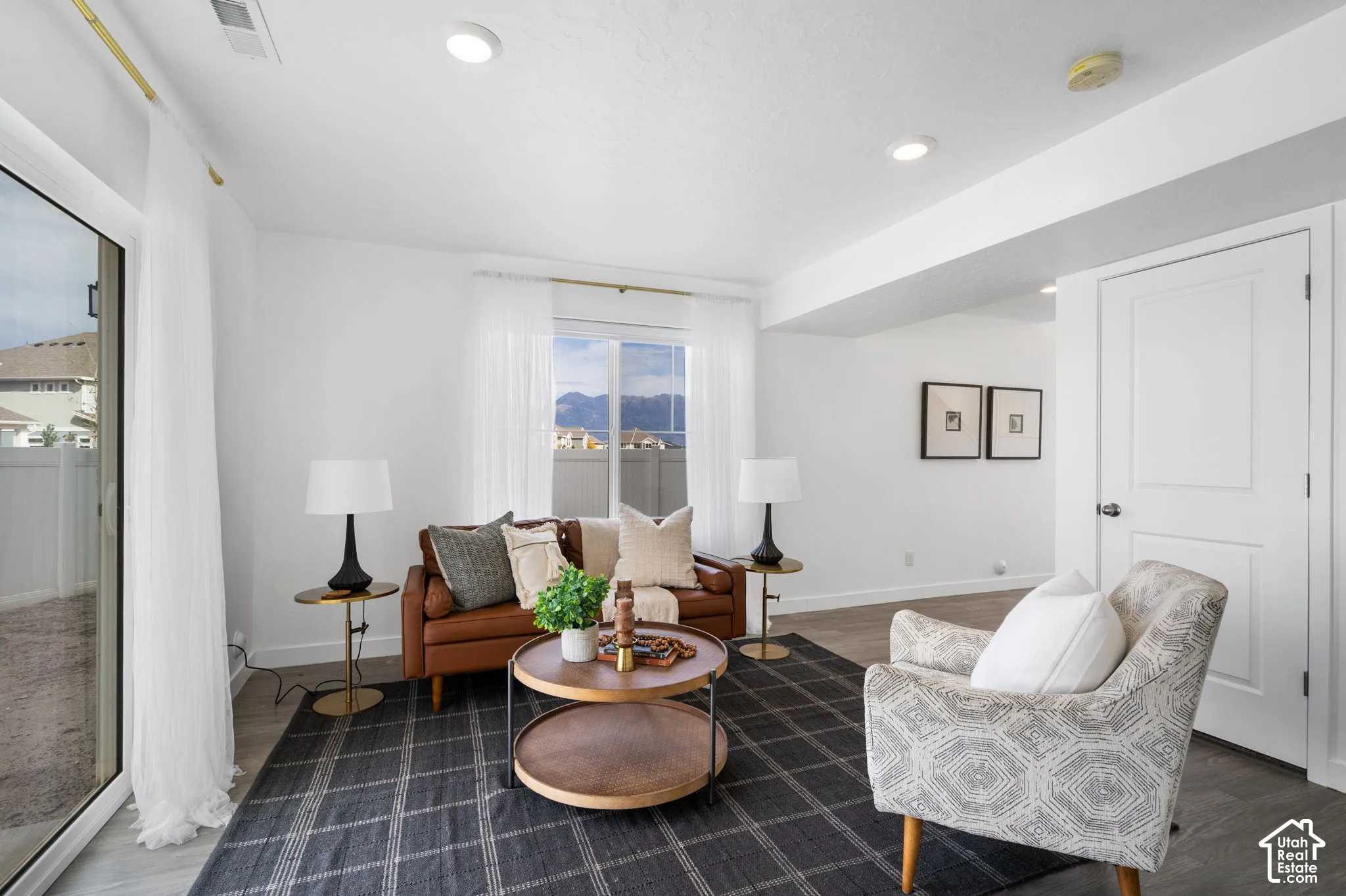Recessed lighting, white walls, and wood-finish flooring