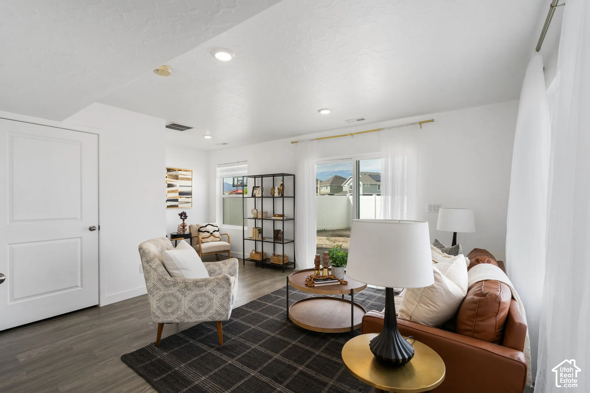 Recessed lighting, wood-finish flooring, white paneled door, and a sliding glass door