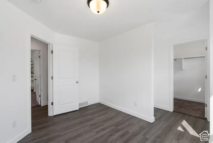 Wood-finish flooring throughout, bright white walls, and a recessed ceiling light