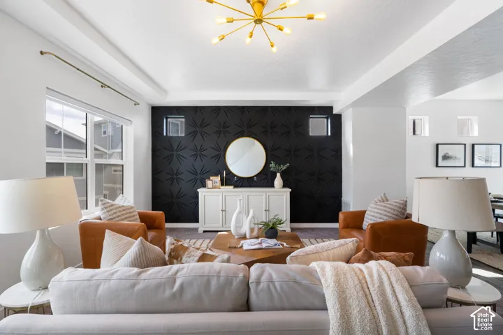 Architectural accent wall, gold sputnik chandelier, coffered ceiling, large windows, and built-in shelving