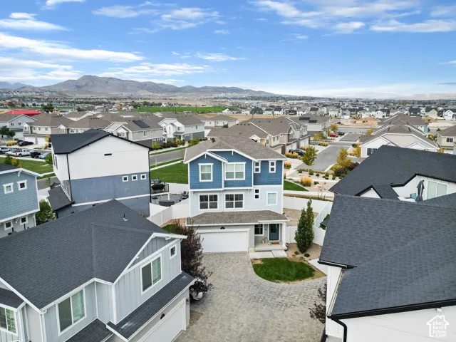 Two-story residence with a blue and light gray exterior, featuring a paved driveway and a two-car garage