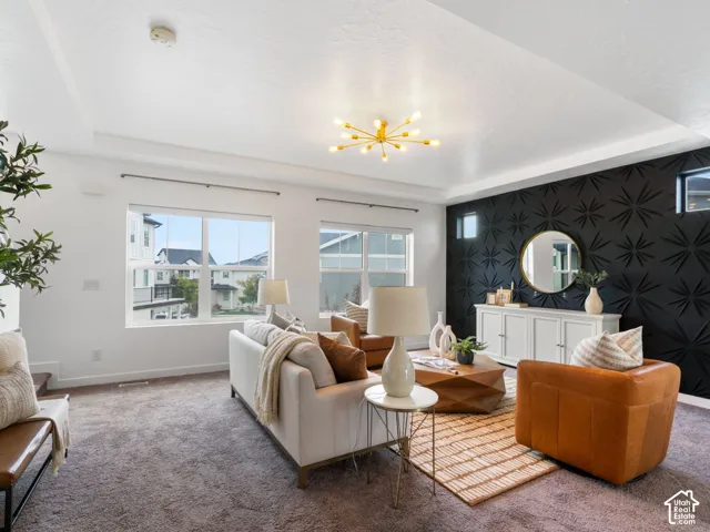 Tray ceiling with a sputnik-style chandelier, textured accent wall, built-in lower cabinetry, and recessed windows