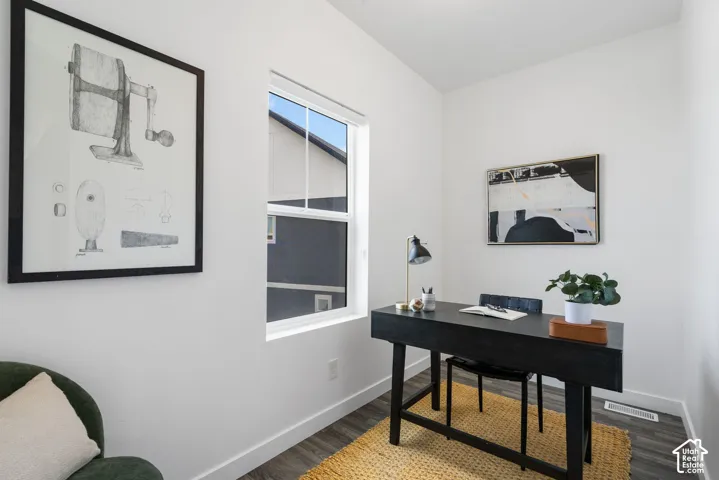 Wood-finish flooring, white walls, and a large window providing ambient light