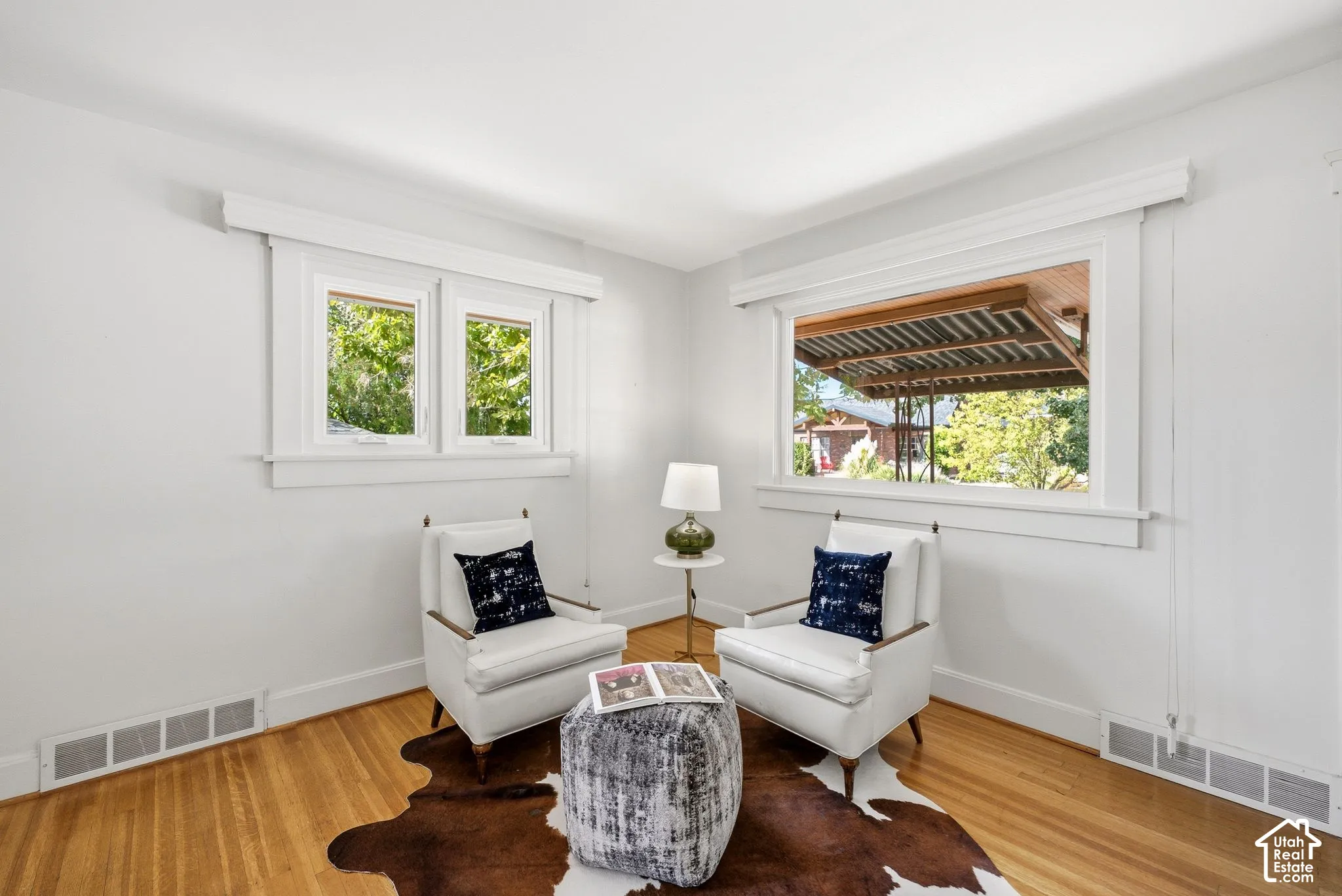 Hardwood flooring, white walls, and white trim molding throughout