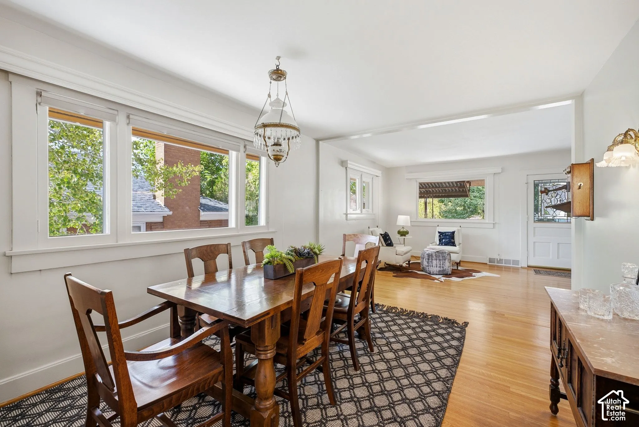 Hardwood flooring extends throughout, complemented by white trim work and a decorative chandelier