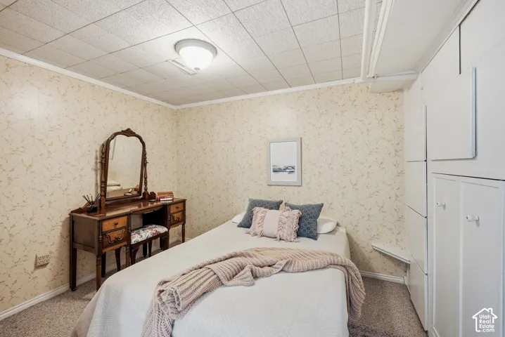 Nonconforming bedroom with wallpapered walls, storage, and a dropped ceiling