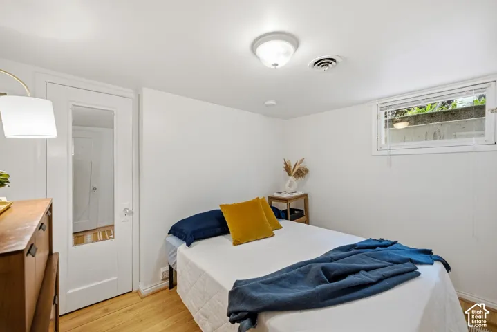 Mother in Law appt bedroom with walk in closet, white walls, and egress window