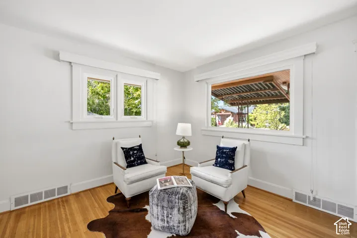 Hardwood flooring, white walls, and white trim molding throughout