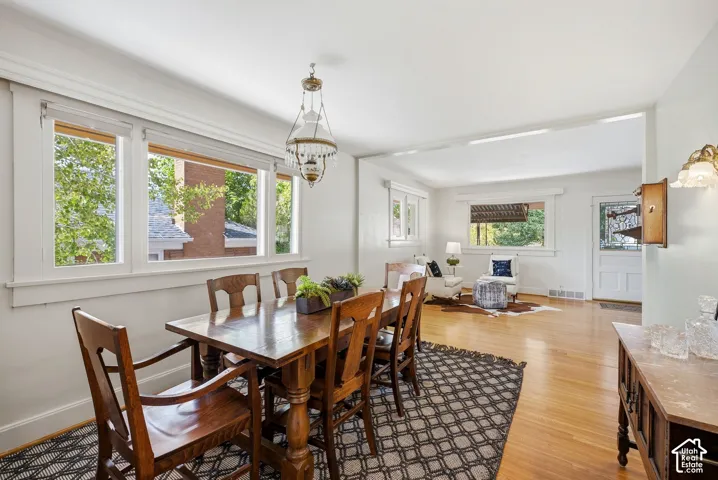 Hardwood flooring extends throughout, complemented by white trim work and a decorative chandelier