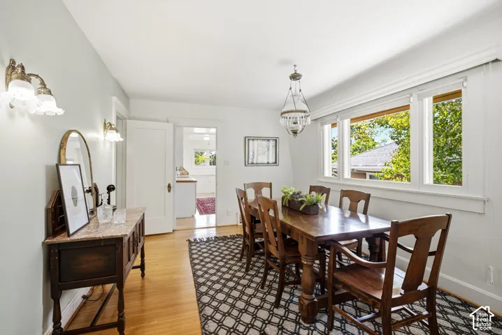 Hardwood flooring throughout, multiple large windows, and a decorative chandelier