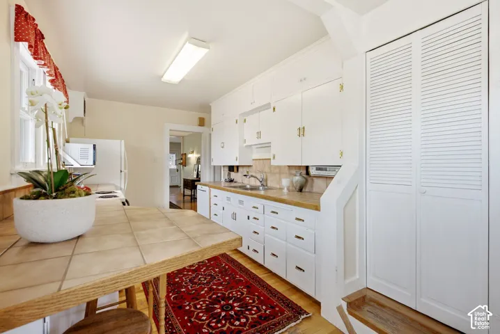 Kitchen featuring white cabinetry, tile countertops, and a breakfast bar
