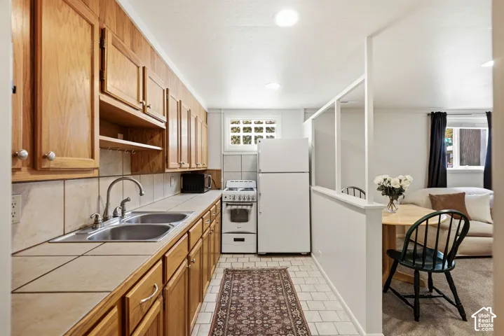 Mother in Law Kitchen featuring wood cabinetry, tile countertops, and a white appliance suite