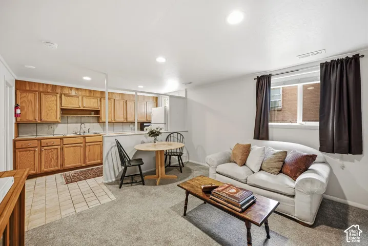 Mother in Law Appt with carpeted living area, recessed lighting, a window, and a kitchen area featuring wood cabinetry, tile backsplash, and tile flooring