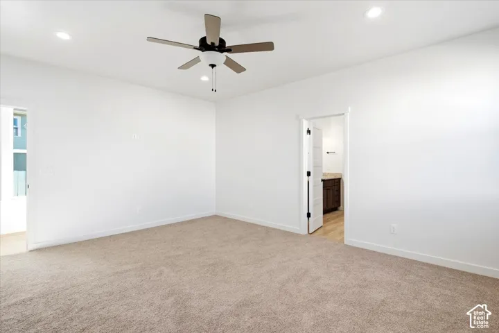 Recessed lighting, ceiling fan, neutral wall paint, neutral carpeting, and white trim