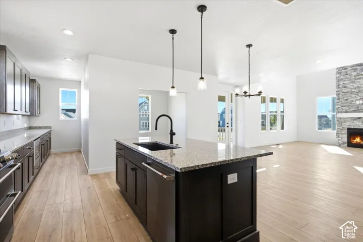 Expansive open-concept kitchen and living area featuring a central island with a built-in sink and pendant lighting
