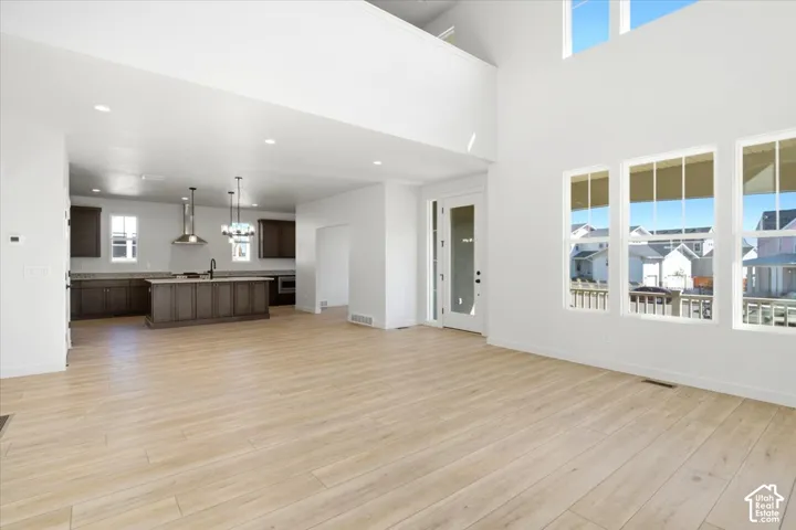 Expansive living space featuring wood-finish flooring and a two-story ceiling