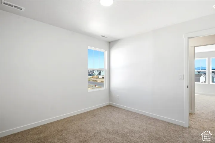 Neutral paint palette, carpet flooring, window with white trim, white baseboards, and a flush mount ceiling light