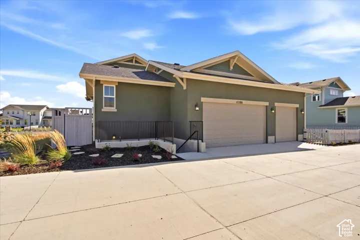Stucco exterior with a dual garage featuring two overhead doors and exterior sconce lighting