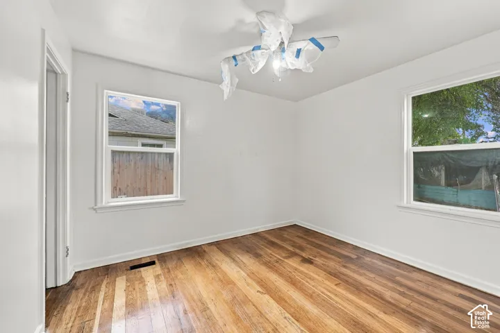 Room featuring neutral wall finishes, wood-finish flooring, and two double-hung windows