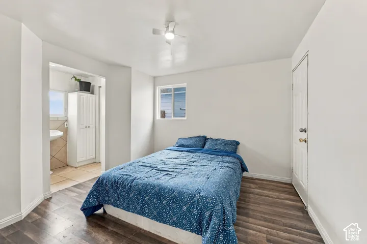 Room with wood-finish flooring, white walls, built-in storage cabinetry, sliding window, and ceiling-mounted light fixture