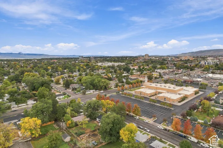 Aerial perspective featuring mature trees, a grid-patterned street layout, and distant mountain topography
