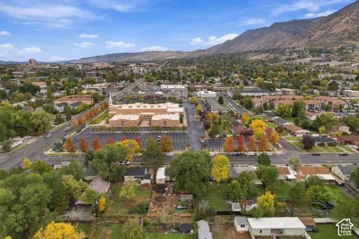 Aerial perspective featuring an expansive neighborhood setting with mature trees and a prominent mountain backdrop
