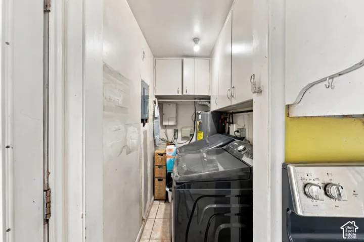 Utility area featuring built-in upper cabinetry and tile flooring