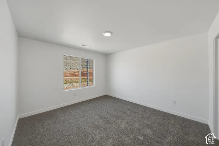 Recessed lighting, neutral wall finishes, gray carpet flooring, and a large window