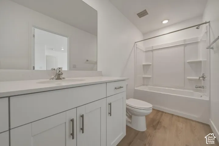 White shaker-style vanity with a light-toned countertop, integrated sink, and modern brushed nickel fixtures