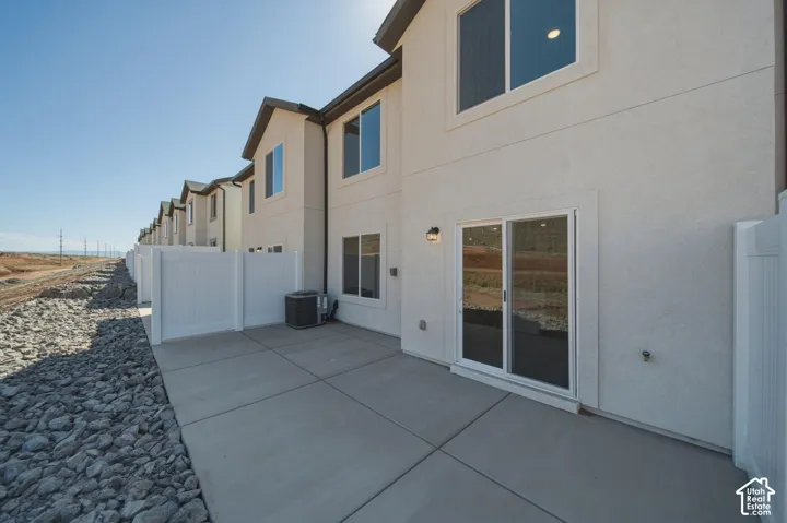 Private outdoor patio with concrete paving and white fencing
