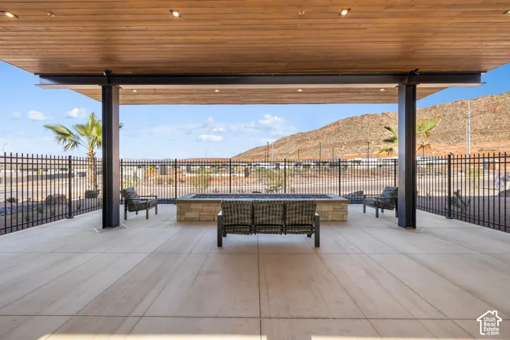 Covered patio featuring a wood-finish ceiling, recessed lighting, and a stone-clad fire pit