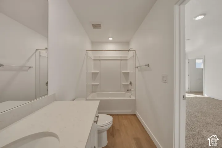 White vanity with an integrated sink, polished chrome faucet, and expansive wall mirror