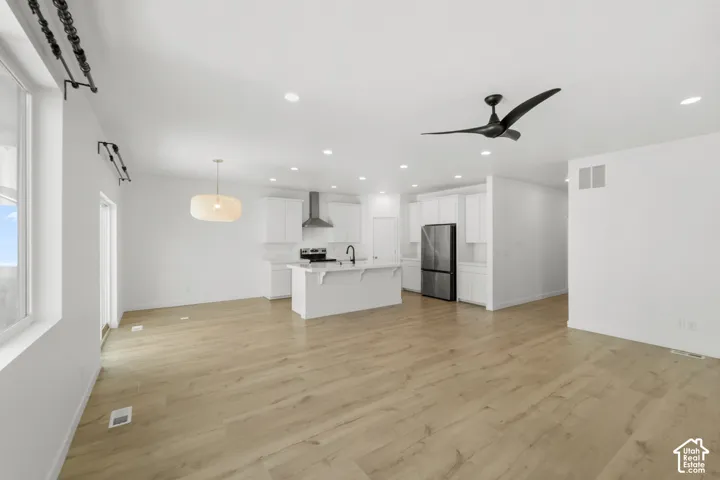 Open concept living space featuring wood-finish flooring, recessed lighting, and a modern ceiling fan
