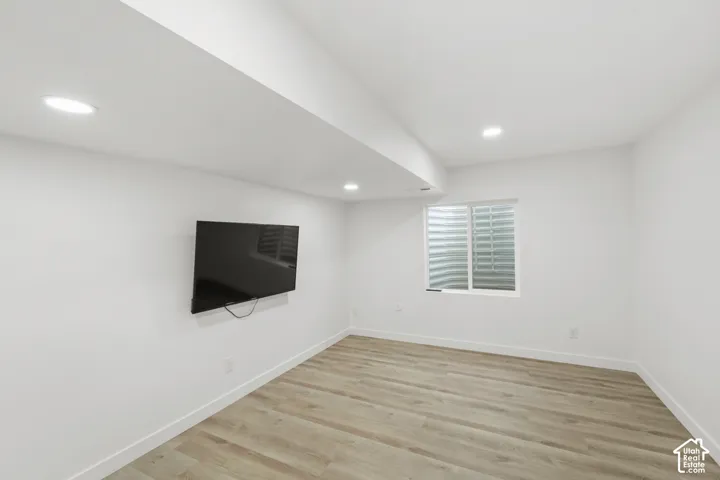 Wood-finish flooring, recessed lighting, and a white-framed window