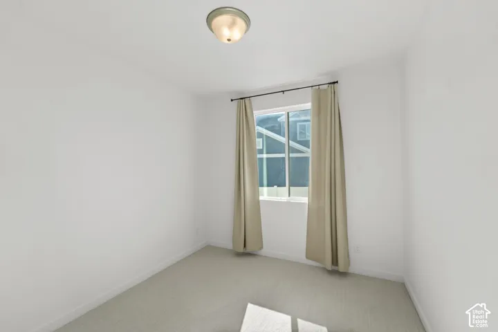Recessed window with drapes, flush mount ceiling light, and light-colored carpeting