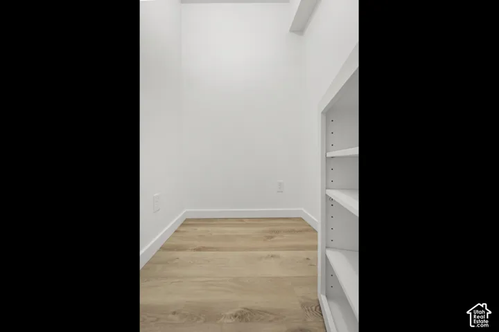 Built-in shelving unit with adjustable shelves and wood-finish flooring
