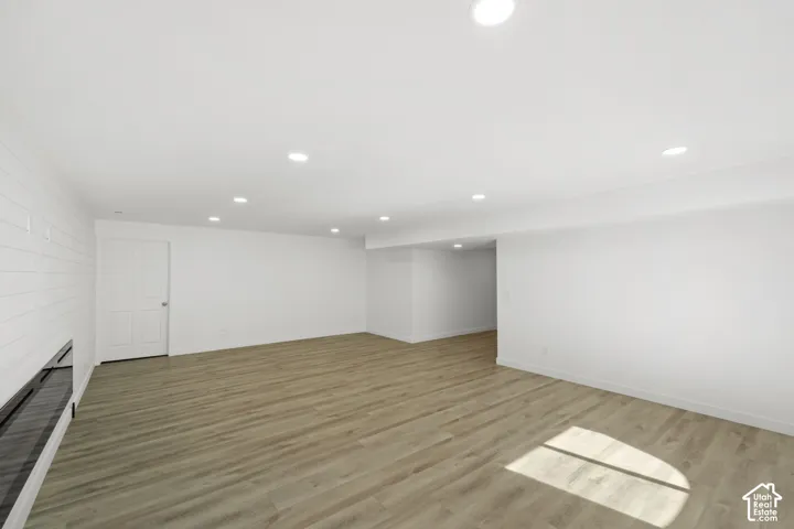 Spacious interior with wood-finish flooring, recessed lighting, and a white paneled accent wall