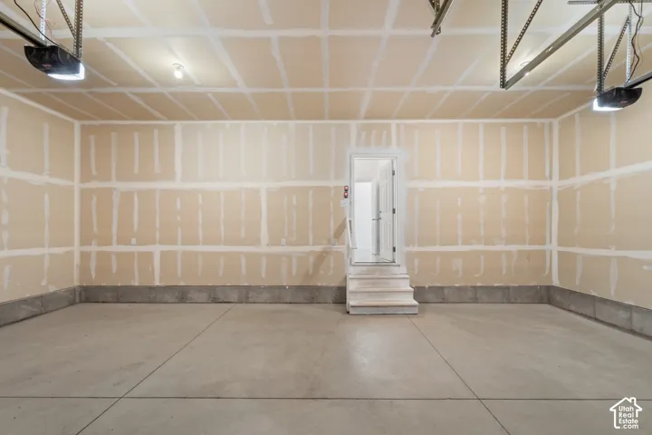 Concrete flooring with expansion joints, unfinished walls, and exposed ceiling joists