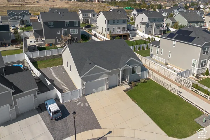 Single-story residence with an attached two-car garage, concrete driveway, and a white fence enclosing the property