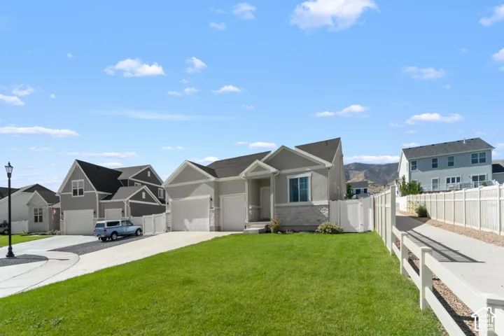Single-story residence featuring a two-car garage, light gray stucco exterior, and a stone facade accent