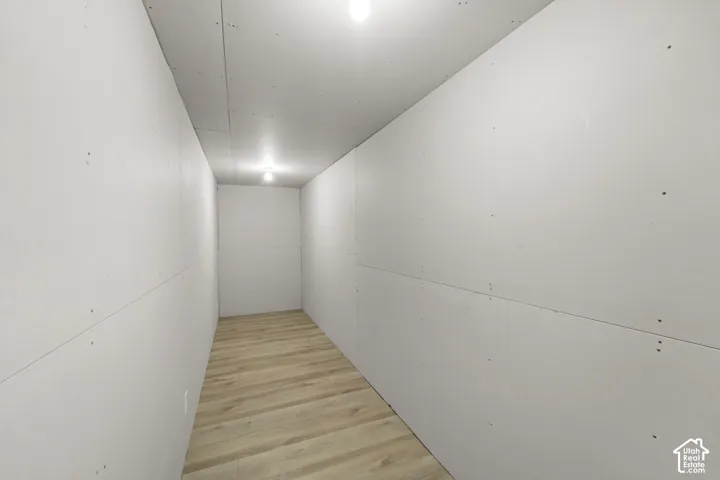 Wood-finish flooring with white walls and overhead lighting