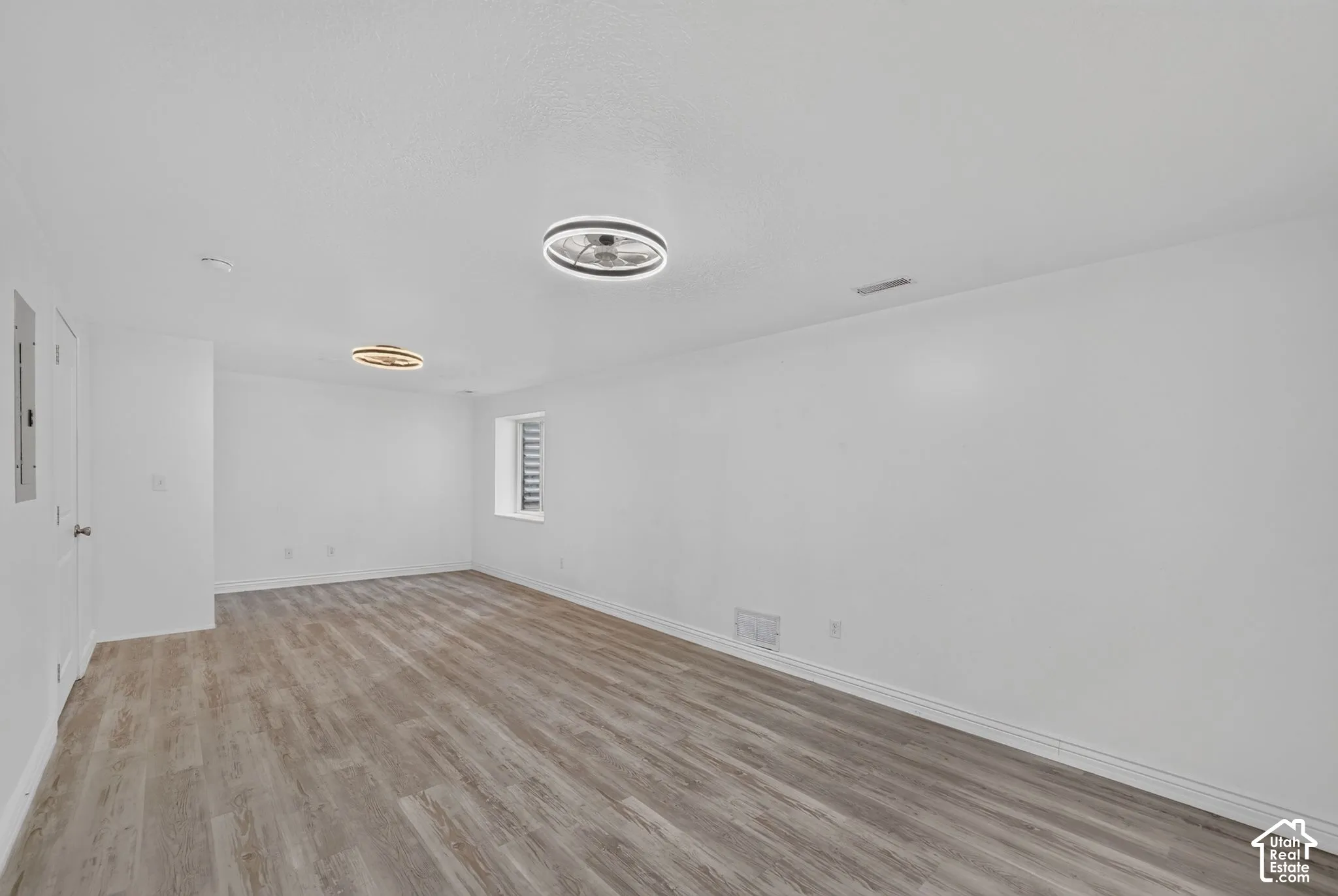 Wood-finish flooring, white walls, and modern ceiling light fixtures