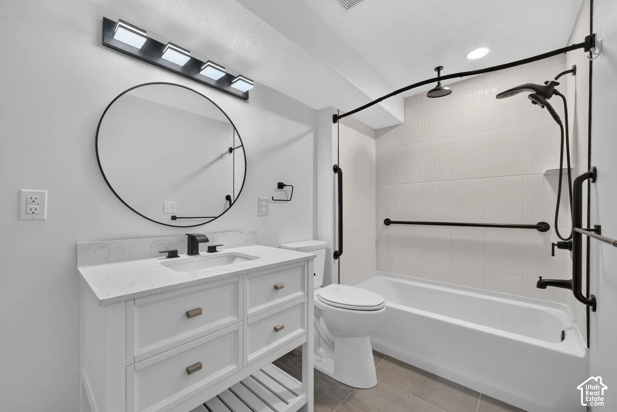Vanity with a solid surface countertop, undermount sink, and matte black fixtures