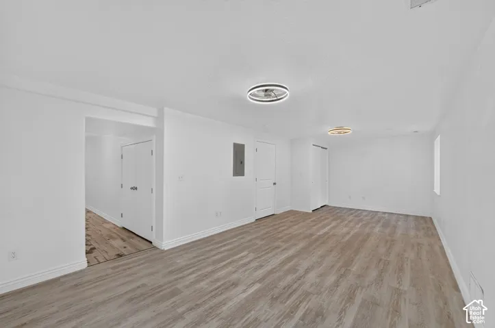 Light wood-finish flooring with white baseboards