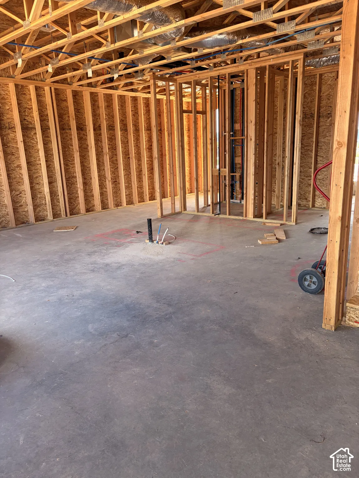 Framed interior space with exposed ceiling joists, subfloor, and rough-in plumbing