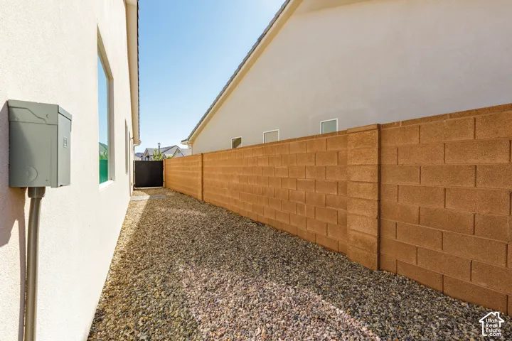 Stucco exterior, gravel ground cover, and a brown block wall