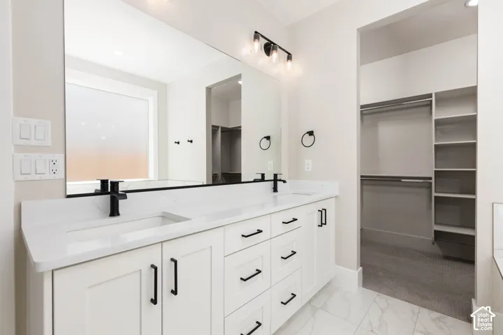 Dual vanity with white cabinetry and black hardware, complemented by an integrated sink and matte black fixtures